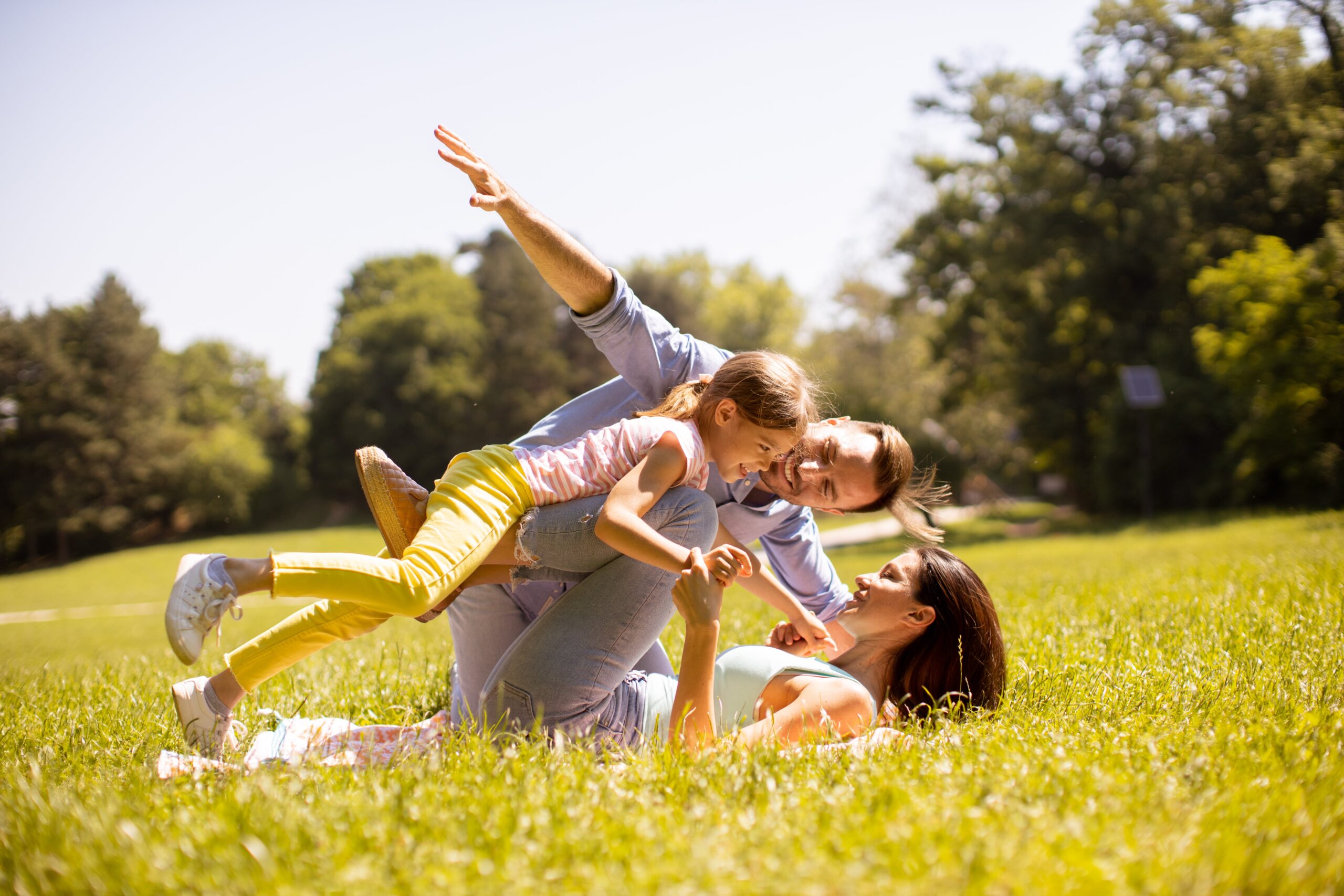 happy-young-family-with-cute-little-daughter-having-fun-park-sunny-day-min
